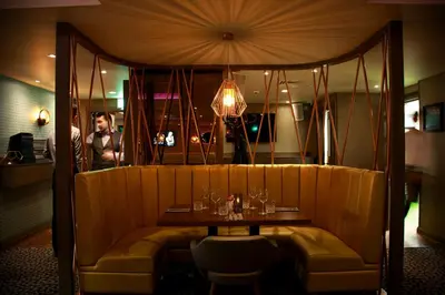 a restaurant with a table and a man in a mirror at Angels Hotel in Uddingston