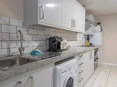a white kitchen with a sink and a dishwasher at City Gem Main Door Parking - Pass the Keys in Glasgow