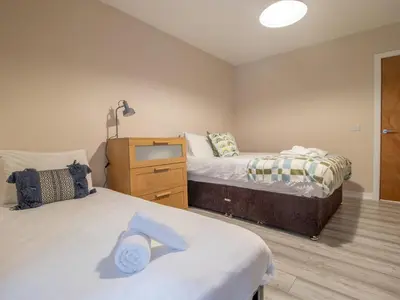 a bedroom with two beds and a dresser in it at City Gem Main Door Parking - Pass the Keys in Glasgow