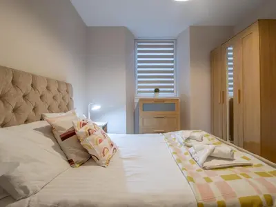 a bedroom with a large white bed with pillows at City Gem Main Door Parking - Pass the Keys in Glasgow