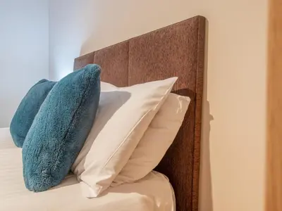 two blue pillows sitting on top of a bed at City Gem Main Door Parking - Pass the Keys in Glasgow