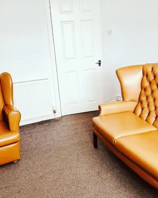 two chairs and a couch in a room with a door at Blue Heaven Apartments in Edinburgh