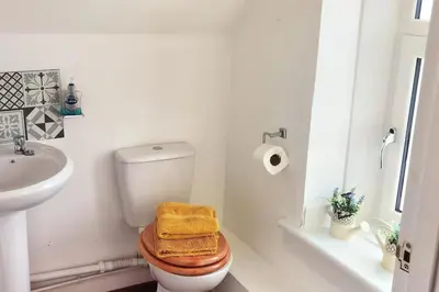 a white bathroom with a toilet and a sink at Quiet Street's Flat with free Parking near Town Centre in Largs