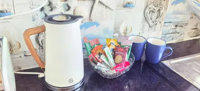 a counter with a container of snacks and a thermos at Quiet Street's Flat with free Parking near Town Centre in Largs