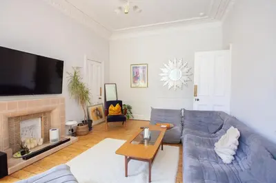 a living room with a blue couch and a fireplace at Lovely Flat in Ideal Location in Glasgow