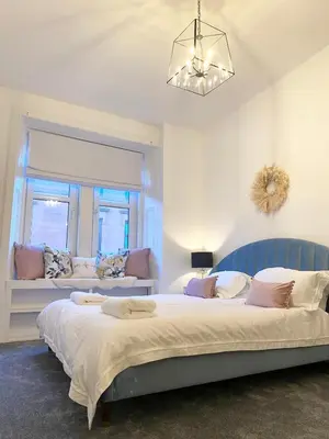 a bedroom with two beds and a window at Boutique West End Apartment - 'The Nook' in Glasgow