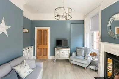 a living room with a couch and a chair at Boutique West End Apartment - 'The Nook' in Glasgow