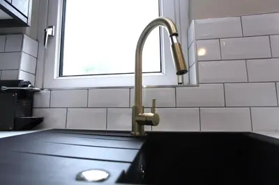 a kitchen sink with a faucet next to a window at Three Bedroom Upper Flat in Jordanhill in Glasgow