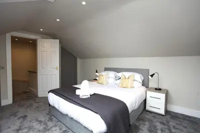 a bedroom with a large bed with white sheets and pillows at Three Bedroom Upper Flat in Jordanhill in Glasgow