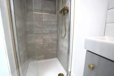 a shower with a glass door next to a sink at Three Bedroom Upper Flat in Jordanhill in Glasgow