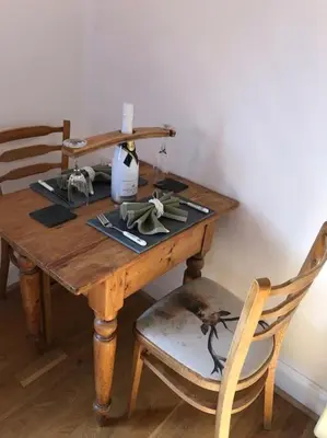 a wooden table with a bottle of wine on it at Station House Flat on outskirts of Thornhill in Thornhill