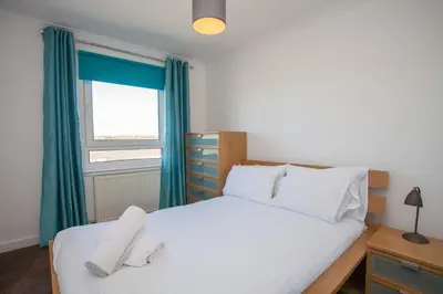 a bedroom with a white bed and a window at 3 Bedroom Duplex with Free Parking in Glasgow