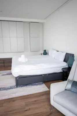 a bedroom with a large bed and a couch at Stunning 3 Bed Penthouse in West End in Glasgow