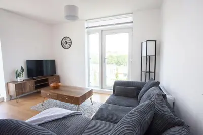 a living room with a blue couch and a tv at Stylish Newly Decorated 2 Bed in Glasgow