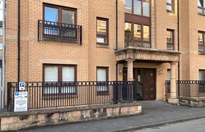 a large brick building with a gate in front of it at The Art Flat Woodlands in Glasgow