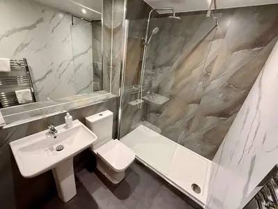 a bathroom with a sink and a toilet and a shower at The Art Flat Woodlands in Glasgow