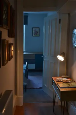 a room with a door and a desk with a lamp at 2 Bedroom Oasis in Glasgow City Centre in Glasgow