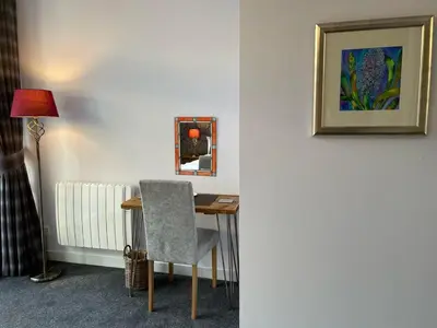 a room with a desk with a chair and a lamp at The Art Flat Glasgow in Glasgow