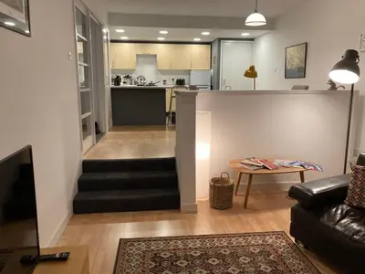 a living room with a staircase leading to a kitchen at The Art Flat Glasgow in Glasgow