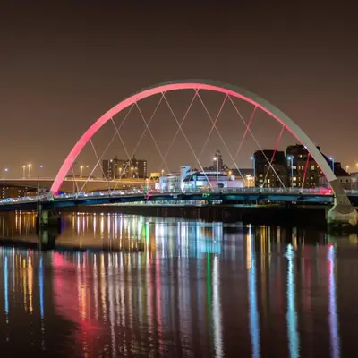a bridge over the water at night with lights at Homely Flat close to Centre with Free Parking in Glasgow