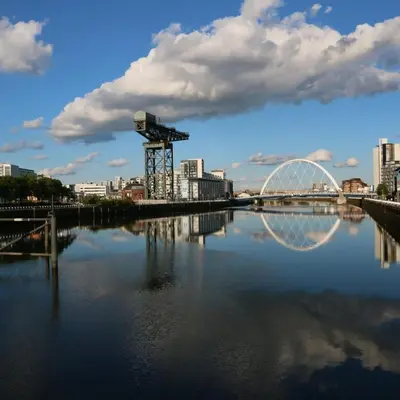 a bridge over a river with a city in the background at Homely Flat close to Centre with Free Parking in Glasgow