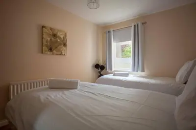 a bedroom with two beds and a window at Homely Flat close to Centre with Free Parking in Glasgow