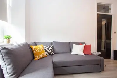 a gray couch with colorful pillows in a living room at Stunning Flat in West End Location in Glasgow