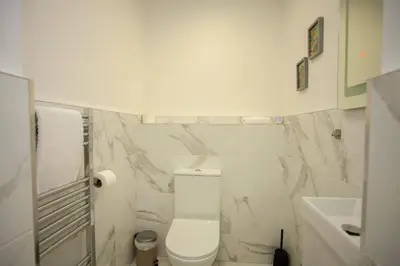 a white bathroom with a toilet and a sink at Beautiful 2 Bed Flat with a Private Terrace in Glasgow