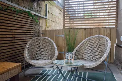 two wicker chairs and a table on a patio at Beautiful 2 Bed Flat with a Private Terrace in Glasgow