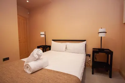 a bedroom with a bed with towels on it at Charming Sandstone-Basement Apartment in West End in Glasgow