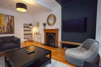 a living room with a couch and a table at Charming Sandstone-Basement Apartment in West End in Glasgow