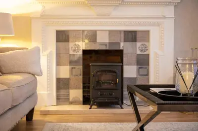 a living room with a fireplace and a couch at The Bradshaw in Prestwick