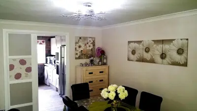 a dining room with a table and flowers on the wall at Double Room in Riverside Apartment - C in Glasgow