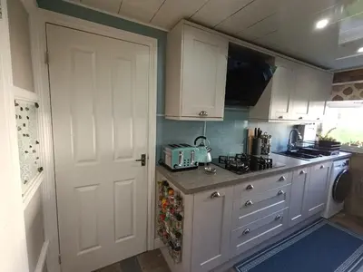 a kitchen with white cabinets and a white door at Double Room in Riverside Apartment - C in Glasgow
