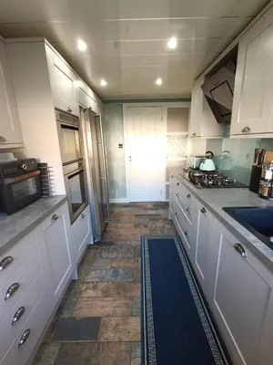 a kitchen with white cabinets and a tile floor at Double Room in Riverside Apartment - C in Glasgow