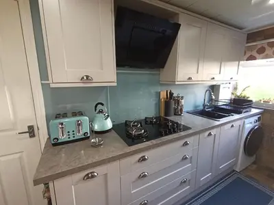 a kitchen with white cabinets and a stove top oven at Double Room in Riverside Apartment - C in Glasgow