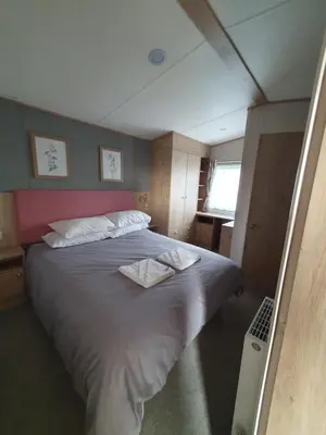 a bedroom with a large bed with two towels on it at Lochgilphead Caravan Park in Lochgilphead
