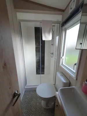 a bathroom with a toilet and a shower and a sink at Lochgilphead Caravan Park in Lochgilphead