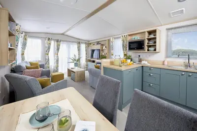 a kitchen and living room with a table and chairs at Lochgilphead Caravan Park in Lochgilphead