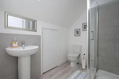 a white bathroom with a sink and a toilet at 3BDR House By Vista Stays Short Lets & Serviced Accommodation Glasgow Scotland With Driveway Parking and PS4 in Glasgow