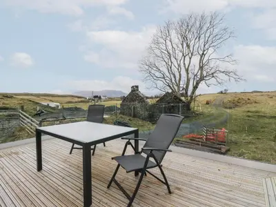 a table and two chairs on a deck with a view at Tirlaggan Úr in Oban