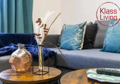 a living room with a table with a vase and a couch at Drumpellier Apartment by Klass Living Coatbridge in Coatbridge