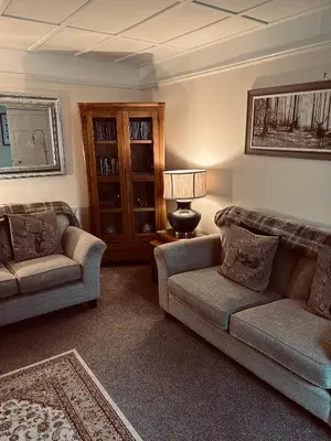 a living room with two couches and a lamp at Lazy Days in Moffat