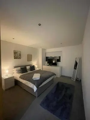 a bedroom with a large bed and a fireplace at Glasgow River Clyde Hydro Aprt in Glasgow