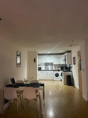 a living room with a table and chairs and a kitchen at Glasgow River Clyde Hydro Aprt in Glasgow
