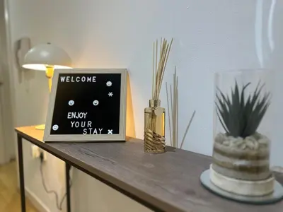 a table with a welcome sign and plants on it at Glasgow River Clyde Hydro Aprt in Glasgow