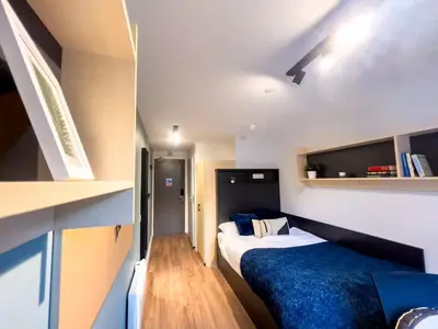 a small room with two beds and a book shelf at For Students Only Portsburgh Court Edinburgh in Edinburgh