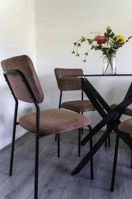 a table with two chairs and a glass table with flowers at Dunbank Apartment in Clydebank