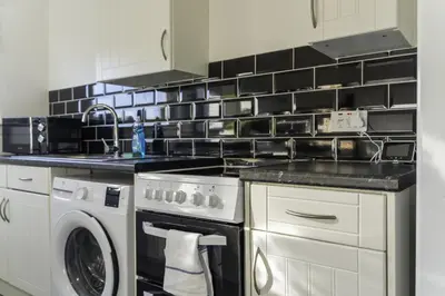 a kitchen with a stove and a dishwasher at Dunbank Apartment in Clydebank