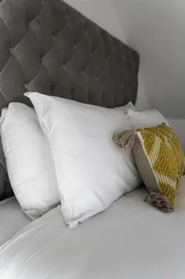 a pile of pillows on a bed with at 3 BDR House By Caledonia Luxe Stays Short Lets & Serviced Accommodation Airdrie in Airdrie
